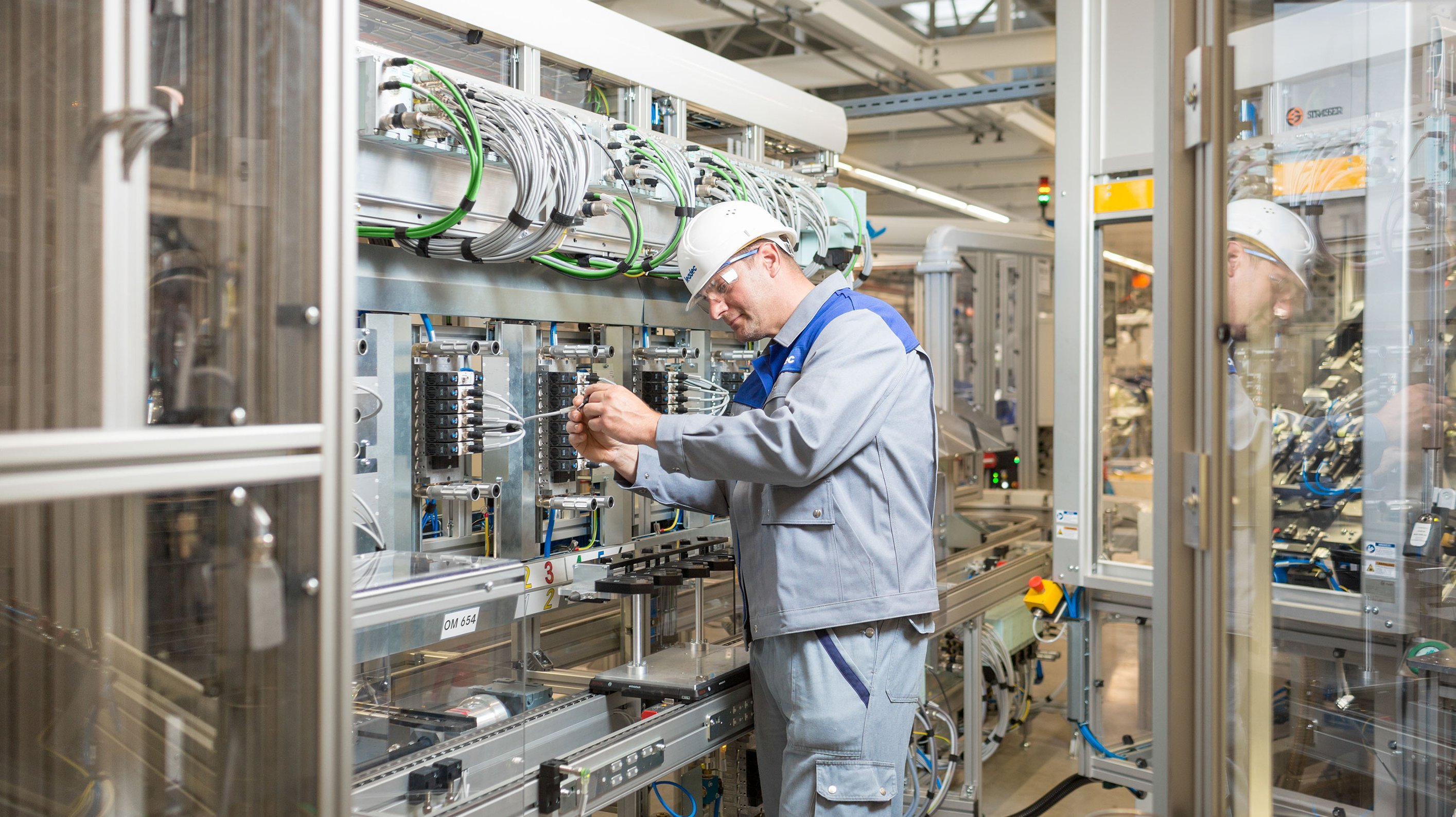 Worker inspecting an electrical Installation at a Leadec plant.