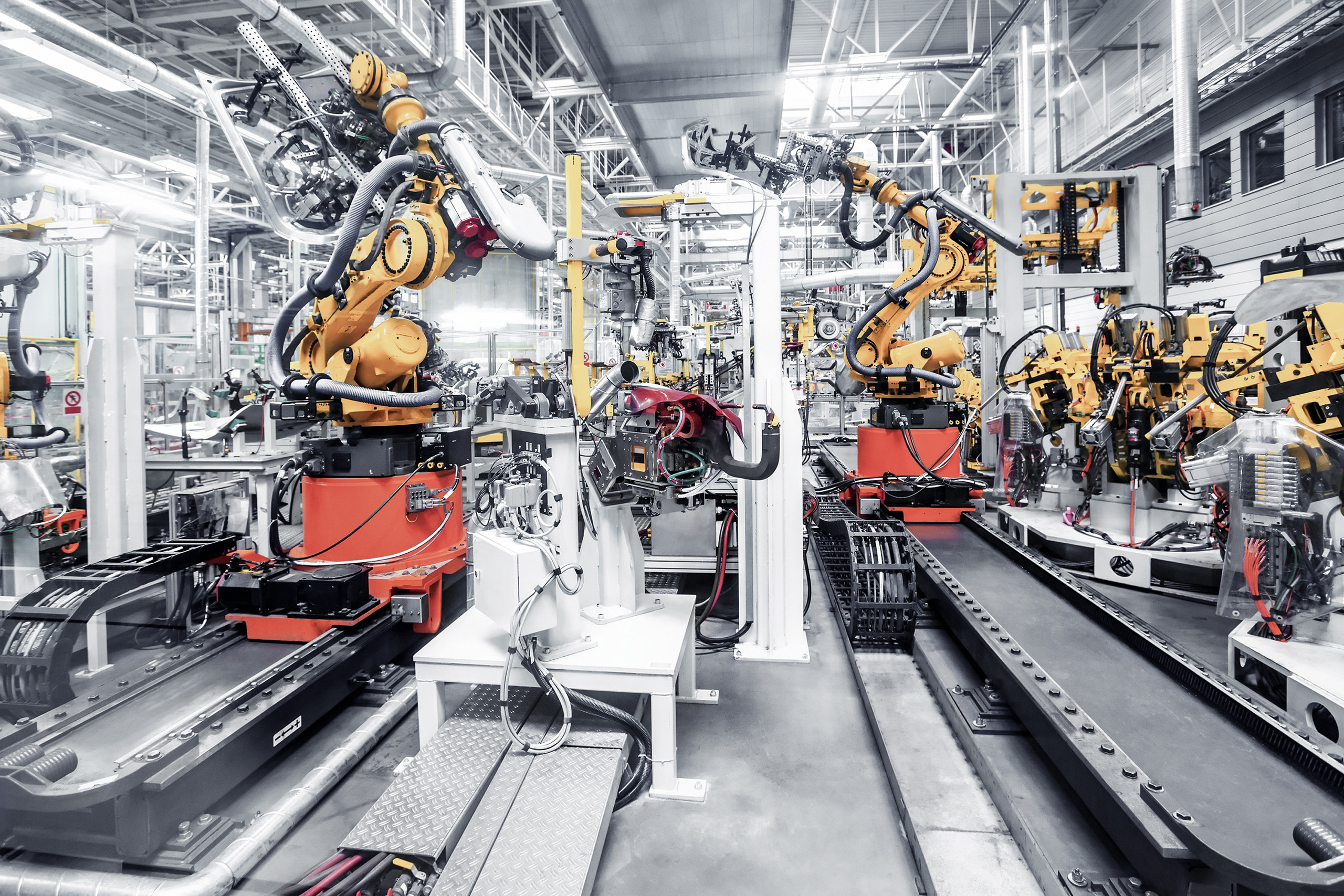 [Translate to Deutschland:] robotic arms in a car plant