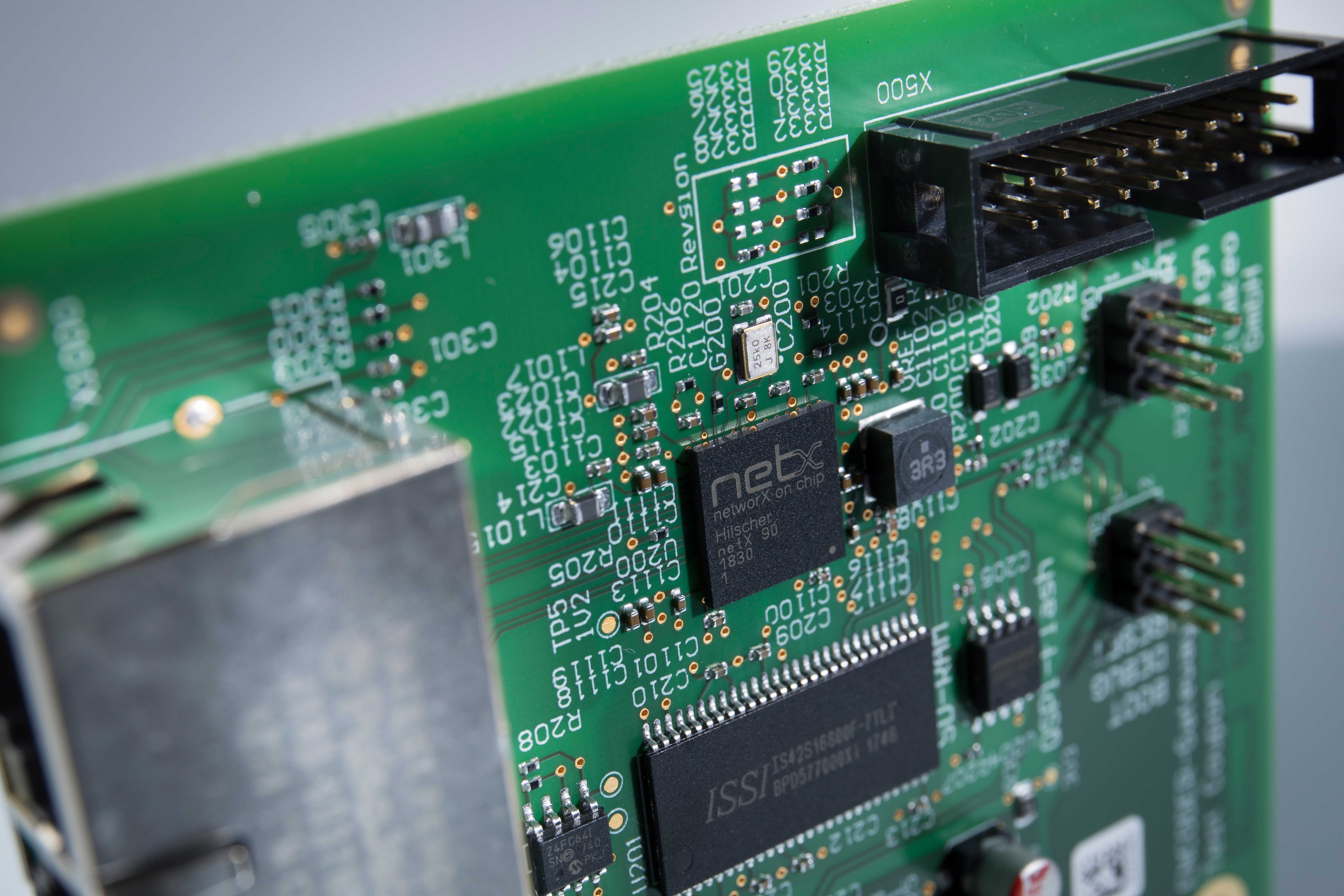 A black netX 90 chip mounted on a green PCB.